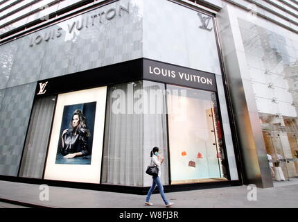 A woman walks past the Louis Vuitton shop in the Suria KLCC
