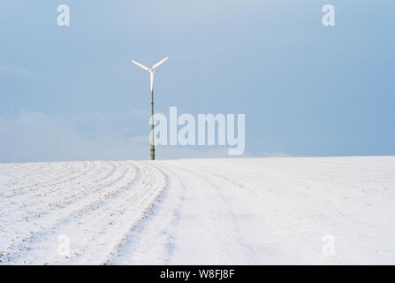 Electric Wind Power Plant on a Snow Covered Hill - A Concept For Renewable Energy Stock Photo