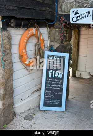 Signs advertsing sale of fish and crabs from small local fisherman's shop. Cadgwith Cove, Cornwall, England Stock Photo