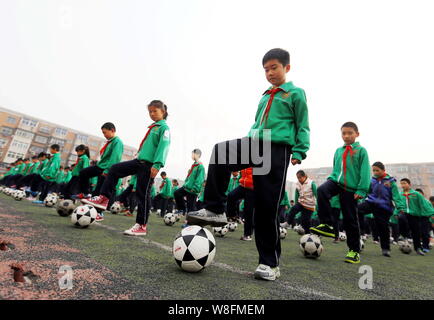 Young Chinese students perform a football exercise at the opening ceremony for the Fourth Campus Football Culture Festival at Yixingbu No.3 Primary Sc Stock Photo