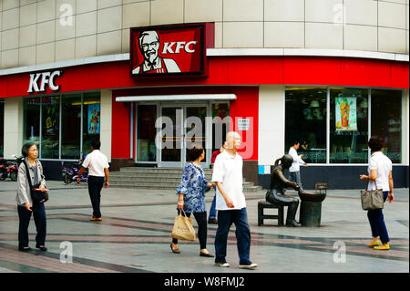 --FILE--Pedestrians walk past a KFC fastfood restaurant of Yum Brands in Yichang city, central China's Hubei province, 30 September 2015.   Shares of Stock Photo