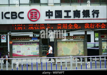 --FILE--A pedestrian walks past a branch of ICBC (Industrial and Commercial Bank of China) in Yichang city, central China's Hubei province, 19 August Stock Photo