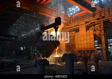 --FILE--Chinese workers survey the production of steel next to a furnace containing molten steel at a plant of Dongbei Special Steel Group Co., Ltd. i