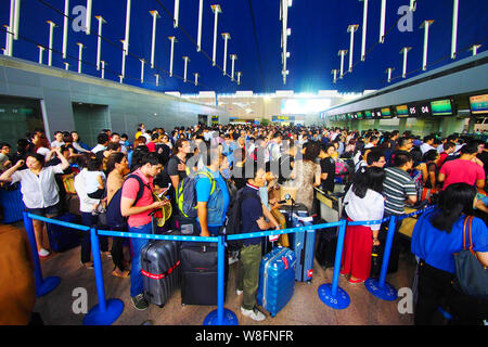 --FILE--A crowd of passengers queue up in front of counters of airlines after their flights were delayed or cancelled due to thunder storms at the Sha Stock Photo