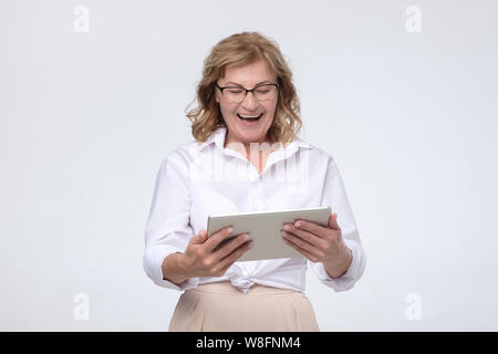 Laughing senior woman using tablet computer to buy some stuff Stock Photo