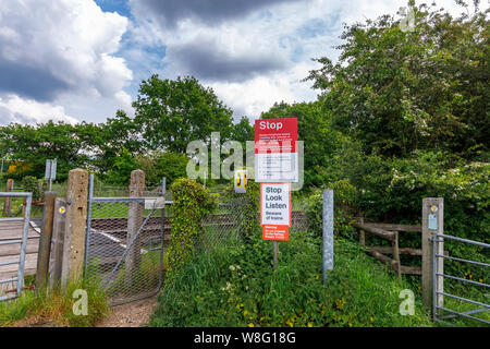 Train warning signs at an unmanned country railway line level crossing in rural Nursling, Redbridge, Test Valley, Southampton, Hampshire Stock Photo