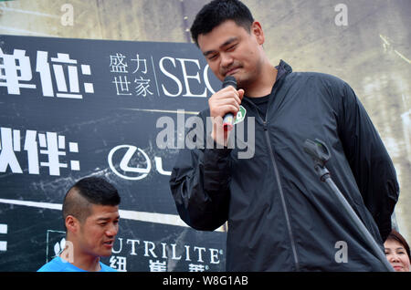 --FILE--Retired Chinese basketball superstar Yao Ming, right, attends the ceremony to start the challenge of running 100 marathons in 100 consecutive Stock Photo