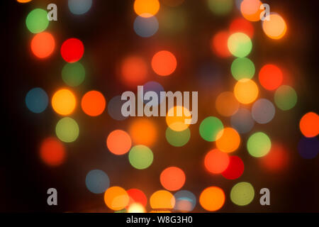 Multicolor bokeh, festive lights on the Christmas tree, defocused lights for Christmas, New Year and a merry holiday background. Stock Photo