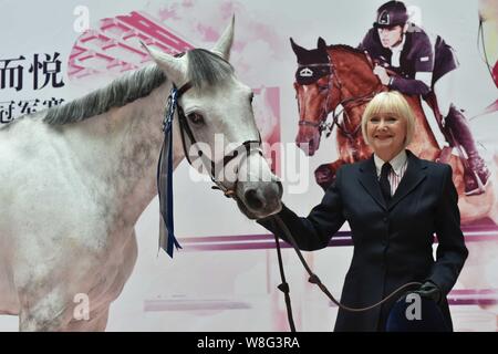 British etiquette expert Diana Mather kisses a horse at an equestrian exhibition at CITIC Pacific Plaza ahead of the 2015 Shanghai Longines Global Cha Stock Photo