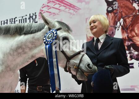 British etiquette expert Diana Mather kisses a horse at an equestrian exhibition at CITIC Pacific Plaza ahead of the 2015 Shanghai Longines Global Cha Stock Photo