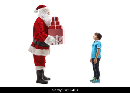 Full length shot of Santa Claus giving a pile of presents to a boy isolated on white background Stock Photo