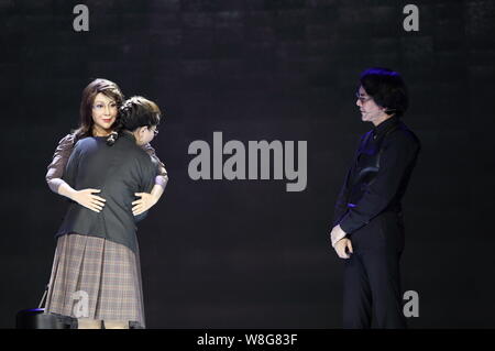 The humanoid robot Android Yang Yang developed by the Intelligent Robotics Laboratory at Osaka University hugs its prototype next to Hiroshi Ishiguro, Stock Photo