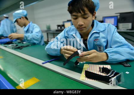 --FILE--Chinese workers assemble smart watches on the assembly line at ...