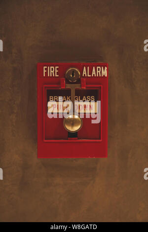 Fire alarm switch box on the wall. Emergency fire extinguisher sign alarm at hotel, hospital or office wall Stock Photo