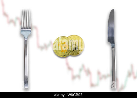 Two Bitcoins crypto currency between fork and knife. Concept of Bitcoin scalability problem. Cryptocurrency market deficit and limitations. Blurred tr Stock Photo