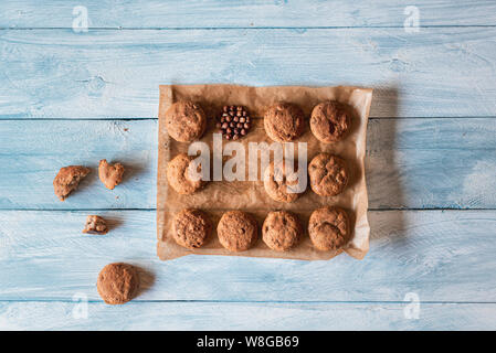 Homemade bread buns with rye flour and hazelnuts, on the baking paper, on a wooden kitchen table. Flat lay of roll bread. Healthy food and copy space Stock Photo