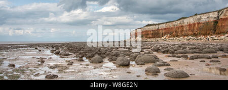 Hunstanton striped cliffs, with rounded boulders on the beach. Stock Photo