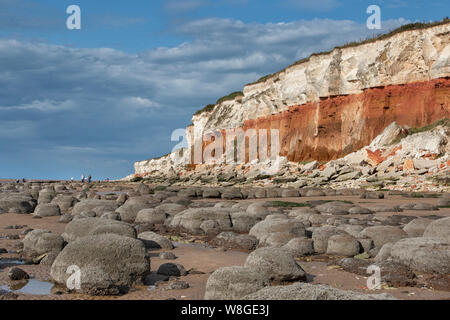 Hunstanton striped cliffs, with rounded boulders on the beach. Stock Photo