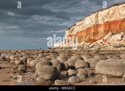 Hunstanton striped cliffs, with rounded boulders on the beach. Stock Photo