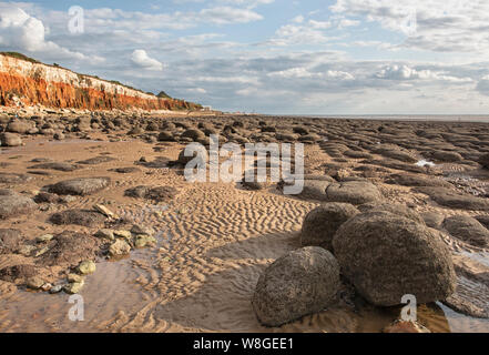 Hunstanton striped cliffs, with rounded boulders on the beach. Stock Photo