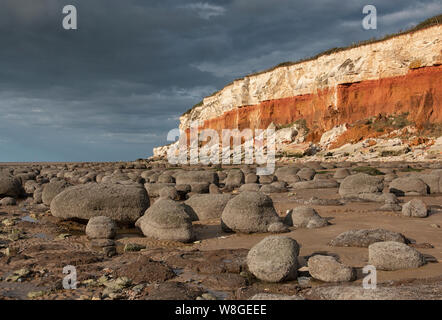 Hunstanton striped cliffs, with rounded boulders on the beach. Stock Photo