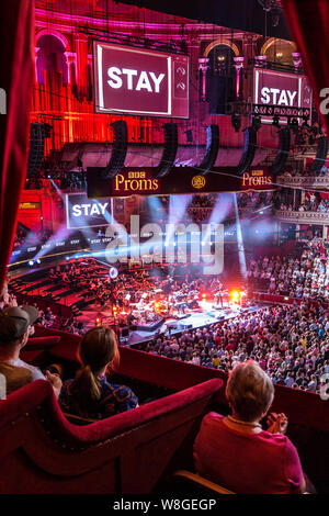 The Royal Albert Hall BBC Proms performance interior viewed from private box in auditorium with audience, sound & spectacular light effects with dramatic eclectic music performance by 'Public Service Broadcasting' and The Multi-Story Orchestra of a work entitled 'The Race For Space' an audio visual spectacular honouringg mans achievements in space. Proms Promenade Concerts Royal Albert Hall Kensington London UK Stock Photo