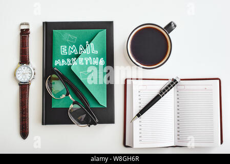Isolated cup of coffee, envelope, pen, notebooks, watch and glasses lying on a white background. Horizontal flat-lay Stock Photo