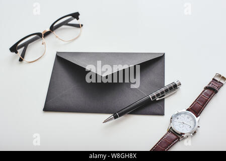 Isolated envelope, pen, watch and glasses lying on a white background. Horizontal shot Stock Photo