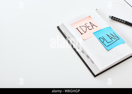 Close up of post notes or post papers that stick on the notebook isolated on white background. Business idea concept Stock Photo