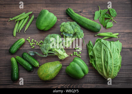 Flat lay series of assorted green toned vegetables, fresh organic raw produce on wooden background Stock Photo