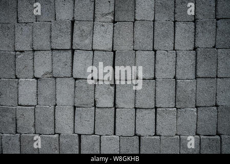 Stack of gray construction bricks closeup. May be used as background Stock Photo