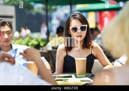 young asian adult friends gathering relaxing in outdoor coffee shop Stock Photo