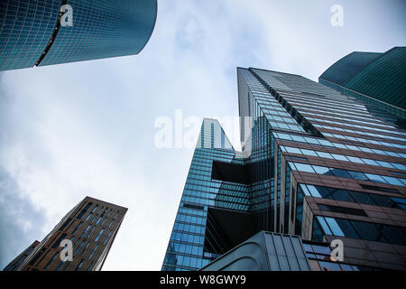 View of the top of modern glass skyscrapers against the blue sky. Architectural business background Stock Photo