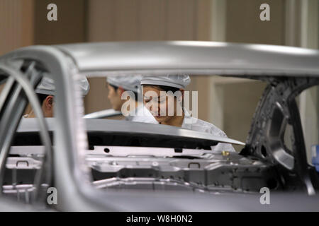--FILE--A female Chinese worker assembles a car on the assembly line at ...