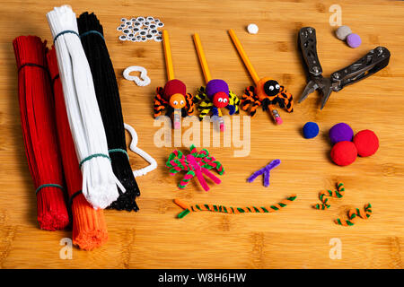Fun Halloween Crafts.  Spiders made of pom poms and pipe cleaners.  Attached to pencils.  Family and kids crafts for fun together.  All the supplies a Stock Photo