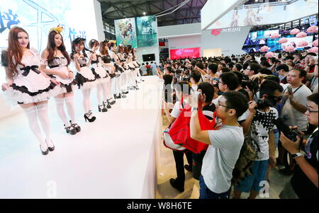 A crowd of visitors take photos of showgirls dressed in maid costumes during the 13th China Digital Entertainment Expo, also known as ChinaJoy 2015, i Stock Photo