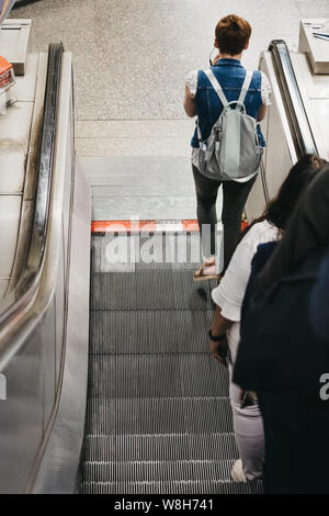 London, UK - July 16, 2019: High angle view of people on the escalator inside London Underground, the oldest underground in the world. Stock Photo