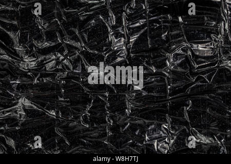 black polyethilene film enforced by sticky tape flat smuggle package closeup texture Stock Photo