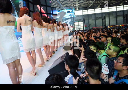 A crowd of visitors look at or take photos of showgirls during the 13th China Digital Entertainment Expo, also known as ChinaJoy 2015, in Shanghai, Ch Stock Photo