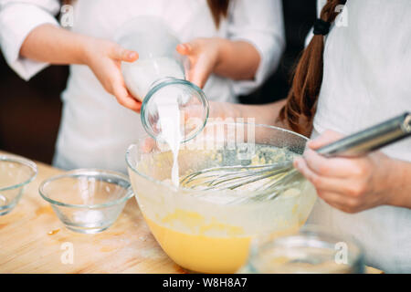 funny girls kids are preparing the dough in the kitchen. Stock Photo