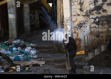 Rio De Janeiro, Brazil. 09th Aug, 2019. A policeman fires into a gang at a protest in the Borel favela over the death of an 18-year-old boy. The boy was supposedly standing at a bus stop when he was hit by a ricochet. According to initial information, a police operation took place at the same time. Credit: Ian Cheibub/dpa/Alamy Live News Stock Photo