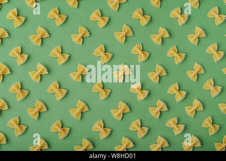Pattern made of pasta on green background. Flat lay. Stock Photo