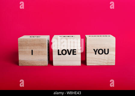 Message 'I love you spelled' in wooden blocks on pink background Stock Photo