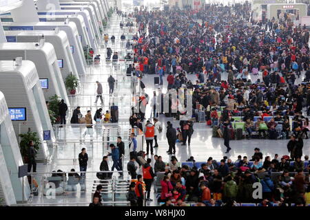 Chinese passengers crowd the Hangzhou East Railway Station as they wait for trains to go back home for Spring Festival to celebrate the Chinese Lunar Stock Photo