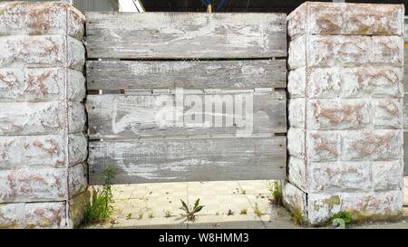 Brick fence with gray wooden shields, selective focus, copyspace Stock Photo