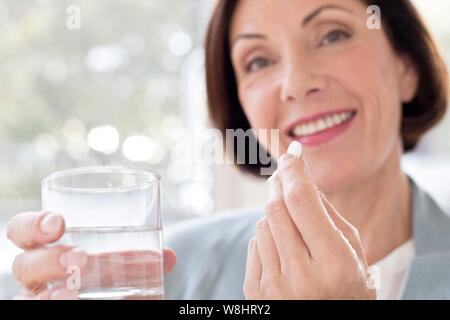 Mature woman taking tablet. Stock Photo
