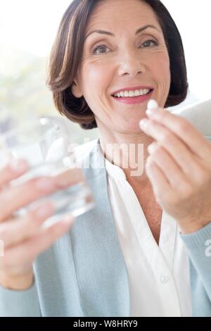 Mature woman taking tablet. Stock Photo
