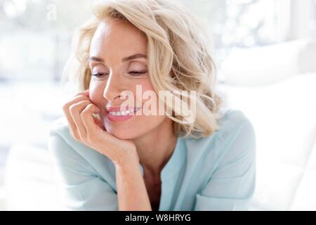 Mature woman smiling and looking away. Stock Photo