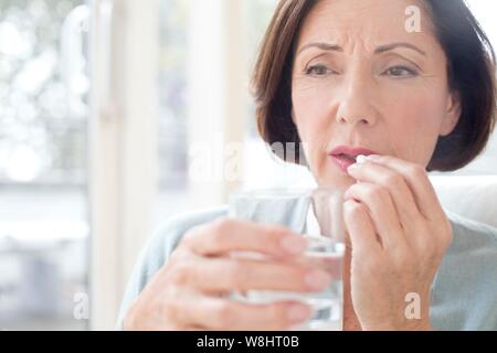 Mature woman taking tablet. Stock Photo