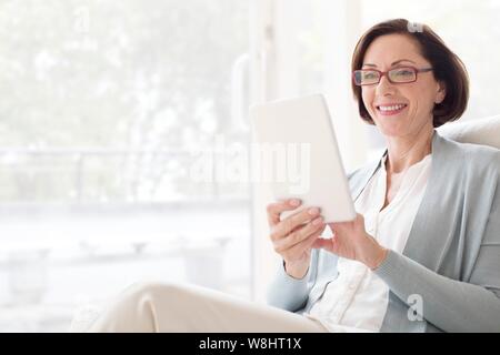 Mature woman using digital tablet. Stock Photo